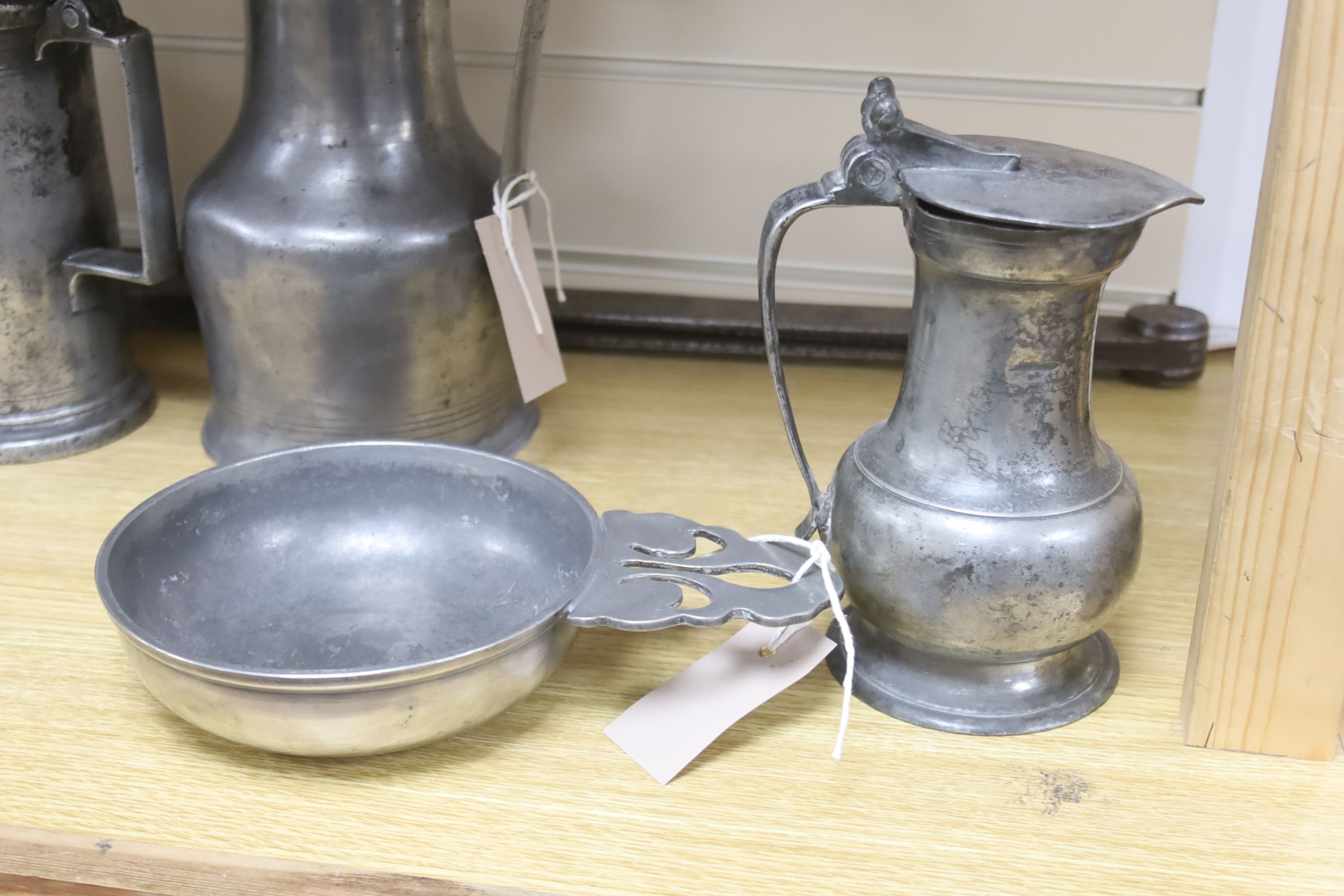 A large pair of steel dividers and a collection of 18th/19th century Continental pewter, including four various flagons, three candlesticks, a chamberstick and a porringer